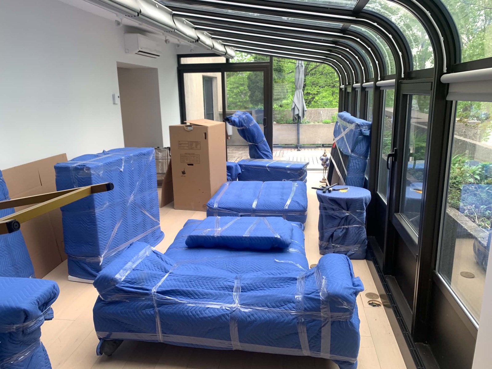 Sofas, tables and a mattress blanket-wrapped and shrink-wrapped, ready to carry out